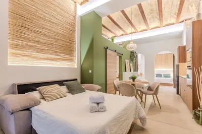 a bedroom with a bed and a dining room at GREEN&FRESH Apartament in Valencia