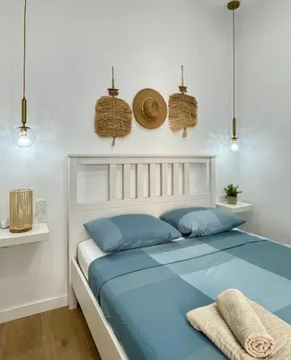 a bedroom with a bed with blue pillows and baskets at UIM Mediterraneo CASA Gomez Ferrer Wifi in Puerto de Sagunto
