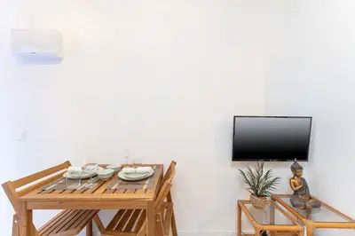 a dining room with a table and a flat screen tv at SOHO BY THE SEA Valencia in Valencia
