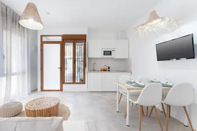 a white kitchen and dining room with a table and chairs at SOHO BY THE SEA Valencia in Valencia
