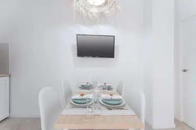 a dining room with a table with chairs and a tv at SOHO BY THE SEA Valencia in Valencia