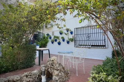 a patio with two chairs and a table in a garden at El Refujio maison independante avec vraie piscine privée au sel chauffee pas de chlore in Turís