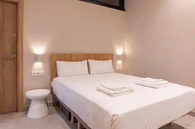 a bedroom with a large white bed with two towels on it at VLC HOST - Molina del Palau in Valencia