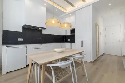 a kitchen with a wooden table and white cabinets at ApartUP Ca La Leni Beach IV in Valencia