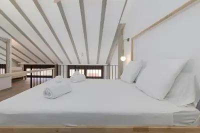 a bedroom with a large white bed with white sheets at ApartUP Ca La Leni Beach IV in Valencia