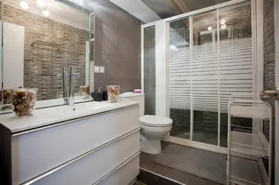 a bathroom with a toilet and a glass shower at 4-Bed Sleeps 7 Free Parking in Valencia