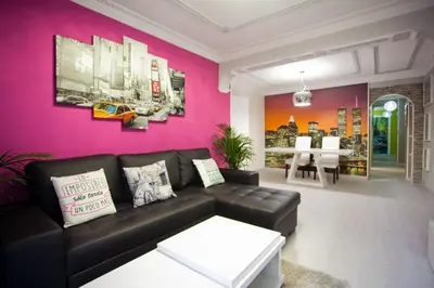 a living room with a couch and a pink wall at 4-Bed Sleeps 7 Free Parking in Valencia