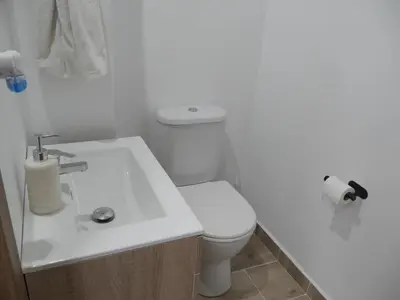 a white bathroom with a toilet and a sink at Casa Vistalmar in Cullera