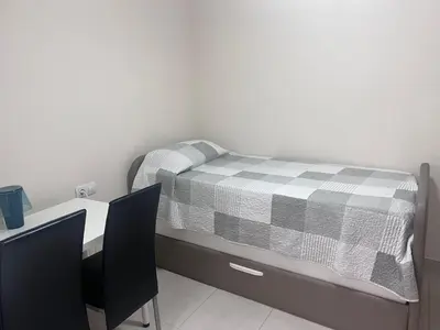 a bedroom with a bed with a desk and chairs at APARTAMENTO Playa Patacona VALENCIA in Valencia