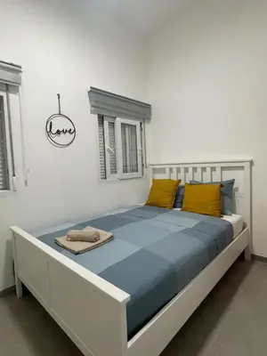 a bedroom with a large bed with yellow pillows at uim mediterraneio PB vicente andres estelles wifi in Puerto de Sagunto