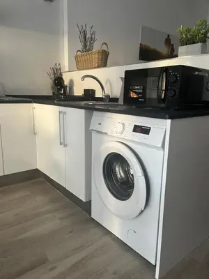 a kitchen with a washing machine and a microwave at Apartamentos ESPIGAS PUERTO in Valencia