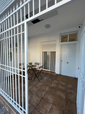 a porch with a table and chairs and a fence at Apartamentos ESPIGAS PUERTO in Valencia