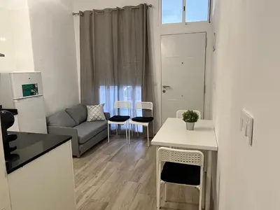 a living room with a couch and a table and chairs at Apartamentos ESPIGAS PUERTO in Valencia