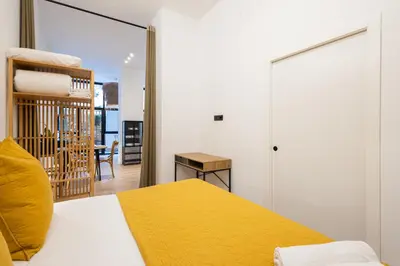 a bedroom with a bed with a yellow blanket at The Blasco Ibañez Apartments in Valencia