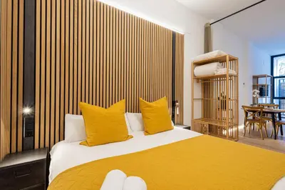 a bedroom with a large bed with yellow pillows at The Blasco Ibañez Apartments in Valencia