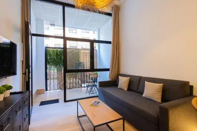 a living room with a couch and a large window at The Blasco Ibañez Apartments in Valencia