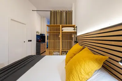 a bedroom with a large bed with yellow pillows at The Blasco Ibañez Apartments in Valencia