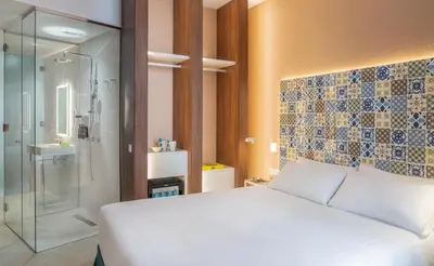 a bedroom with a white bed and a glass shower at Axel Hotel Valencia - Adults Only in Valencia