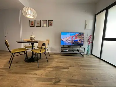 a living room with a table and a tv at Junto al Jardín del Turia Apartamento in Valencia