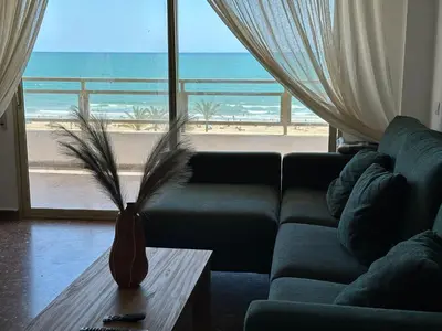 a living room with a couch and a view of the beach at Euromar Playa Cullera frente al mar con garaje in Cullera