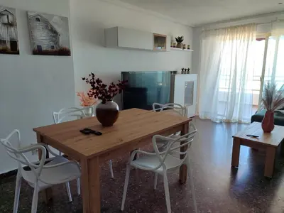 a dining room table with chairs and a vase on it at Euromar Playa Cullera frente al mar con garaje in Cullera