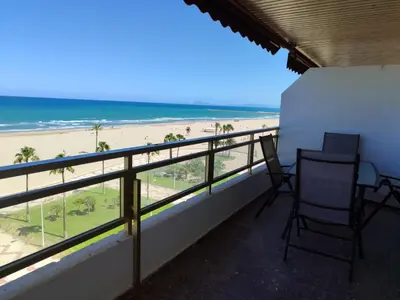 a balcony with two chairs and a view of the beach at Euromar Playa Cullera frente al mar con garaje in Cullera