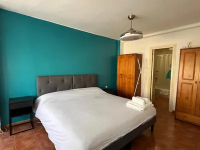 a bedroom with a bed with a blue wall at Valencia nuevo centro in Valencia