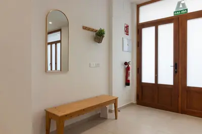 a hallway with a wooden bench and a mirror at VLC HOST - Alfaro A in Valencia