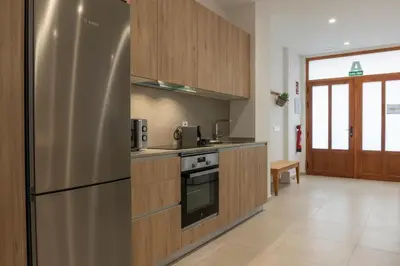 a kitchen with a stainless steel refrigerator and wooden cabinets at VLC HOST - Alfaro A in Valencia