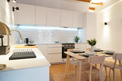 a kitchen with white cabinets and a table and chairs at Apartamento Ático en Valencia in Valencia
