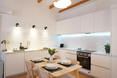 a white bedroom with a bed and two windows at Apartamento Ático en Valencia in Valencia