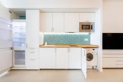 a white kitchen with a sink and a dishwasher at Julio's Apartment in Valencia