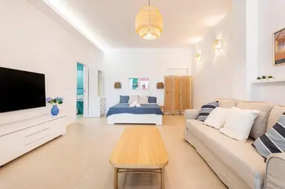 a living room with a couch and a tv and a bed at Julio's Apartment in Valencia