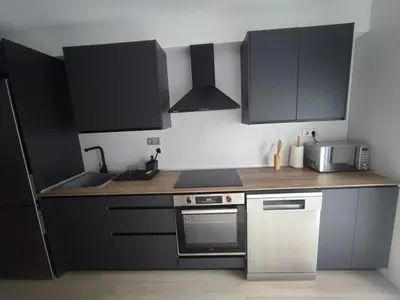 a kitchen with black cabinets and a stove top oven at Casa Salvador, Escapada de Aventura y Relax en Buñol in Buñol