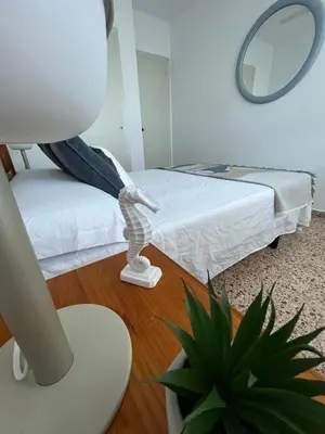 a room with a bed and a mirror and a plant at Caballito de Mar in Tavernes de Valldigna
