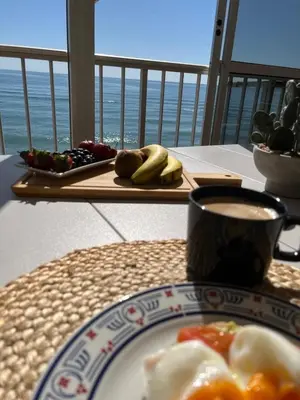 a table with a plate of food and a cup of coffee at Caballito de Mar in Tavernes de Valldigna