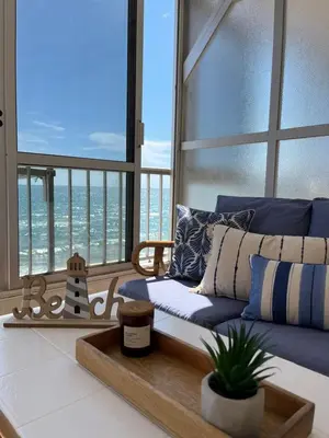 a living room with a blue couch in front of a window at Caballito de Mar in Tavernes de Valldigna