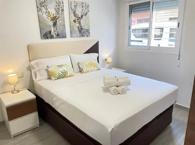 a bedroom with a large white bed with a box on it at Seahorse apartment El Perelló in El Perelló