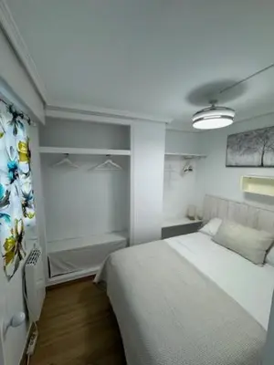 a bedroom with a white bed in a room at Apartamento Arenal 1a Linea de Playa in Cullera