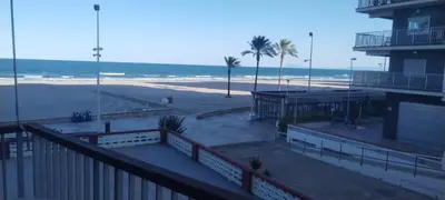 a view of a beach with a building and the ocean at Apartamento Arenal 1a Linea de Playa in Cullera