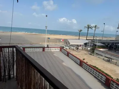 a boardwalk next to a beach with the ocean at Apartamento Arenal 1a Linea de Playa in Cullera