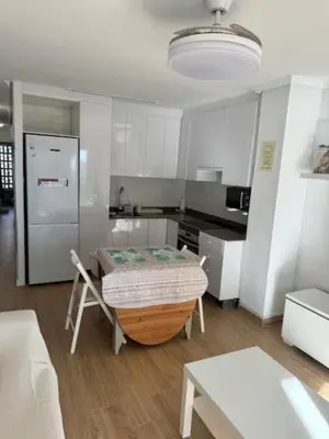a kitchen with a table in the middle of a room at Apartamento Arenal 1a Linea de Playa in Cullera