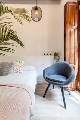 a bedroom with a blue chair next to a bed at Modern Flat by Mercado Central in Ciutat Vella in Valencia