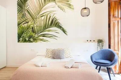 a bedroom with a bed and a blue chair at Modern Flat by Mercado Central in Ciutat Vella in Valencia