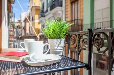 a table with a book and coffee cups and a book at Modern Flat by Mercado Central in Ciutat Vella in Valencia
