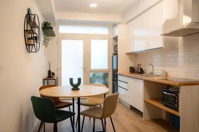 a small kitchen with a wooden table and chairs at Green Relax Leones in Valencia