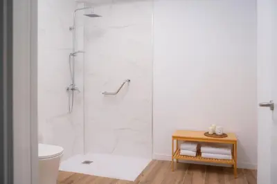 a white bathroom with a shower and a toilet at Green Relax Leones in Valencia