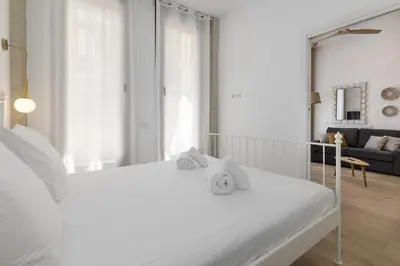 a bedroom with a white bed with towels on it at ApartUP Ca La Leni Beach I in Valencia