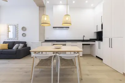 a kitchen and dining room with a table and chairs at ApartUP Ca La Leni Beach I in Valencia