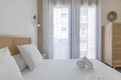 a bedroom with a white bed with towels on it at ApartUP Ca La Leni Beach III in Valencia